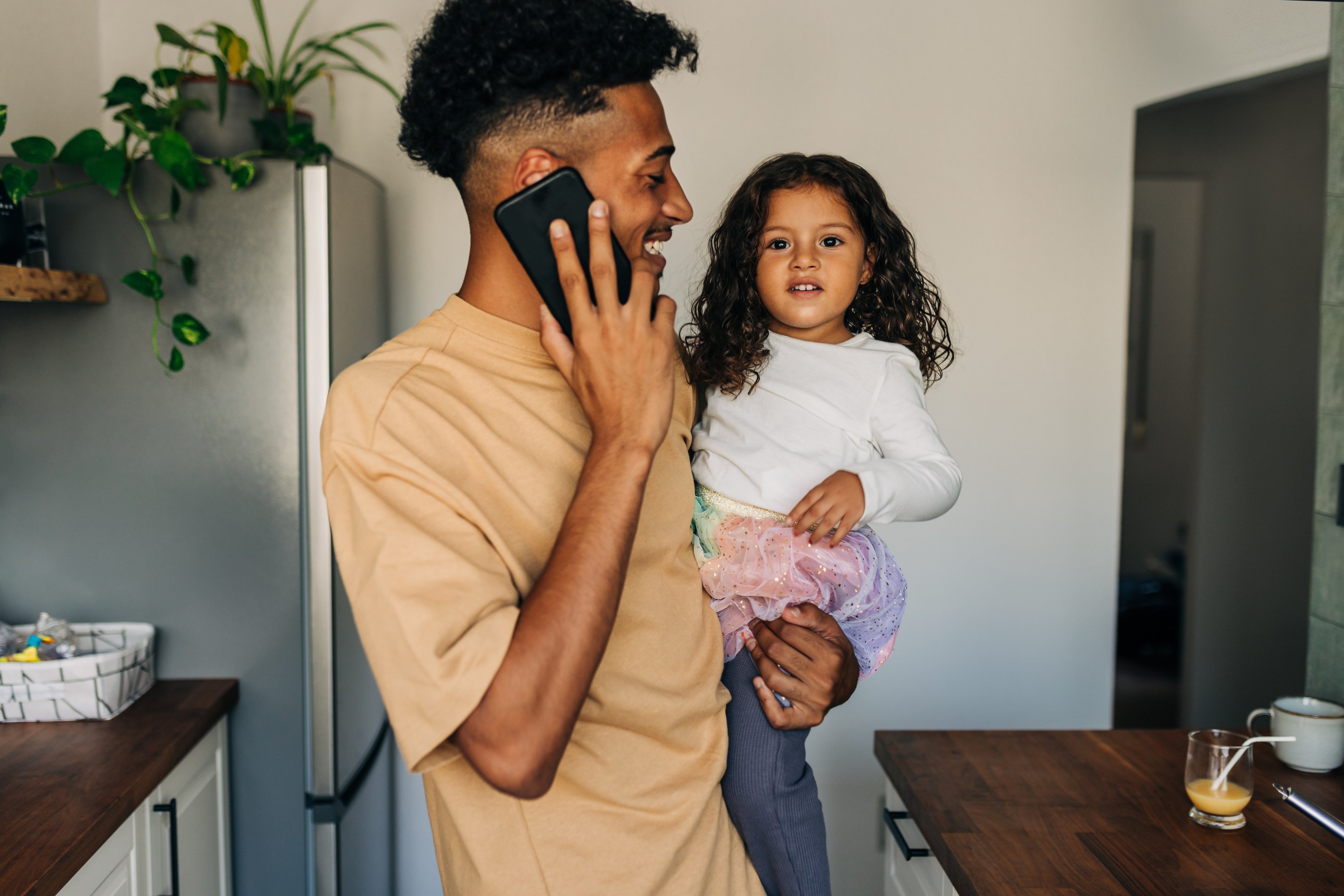 Man on phone holding daughter